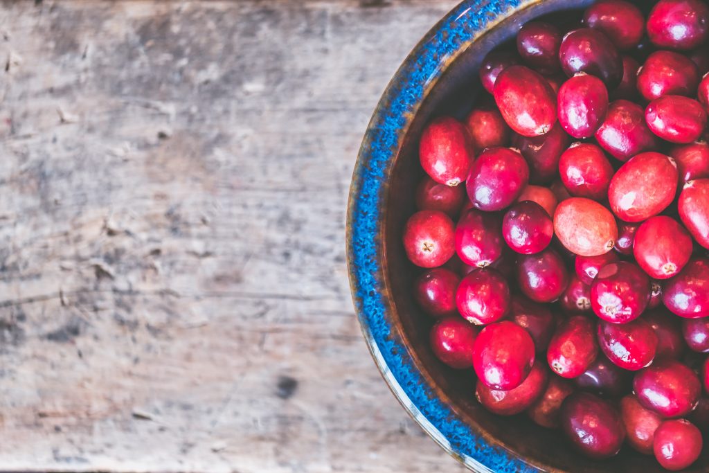 closeup shot of red coffee beans on a wooden gray background