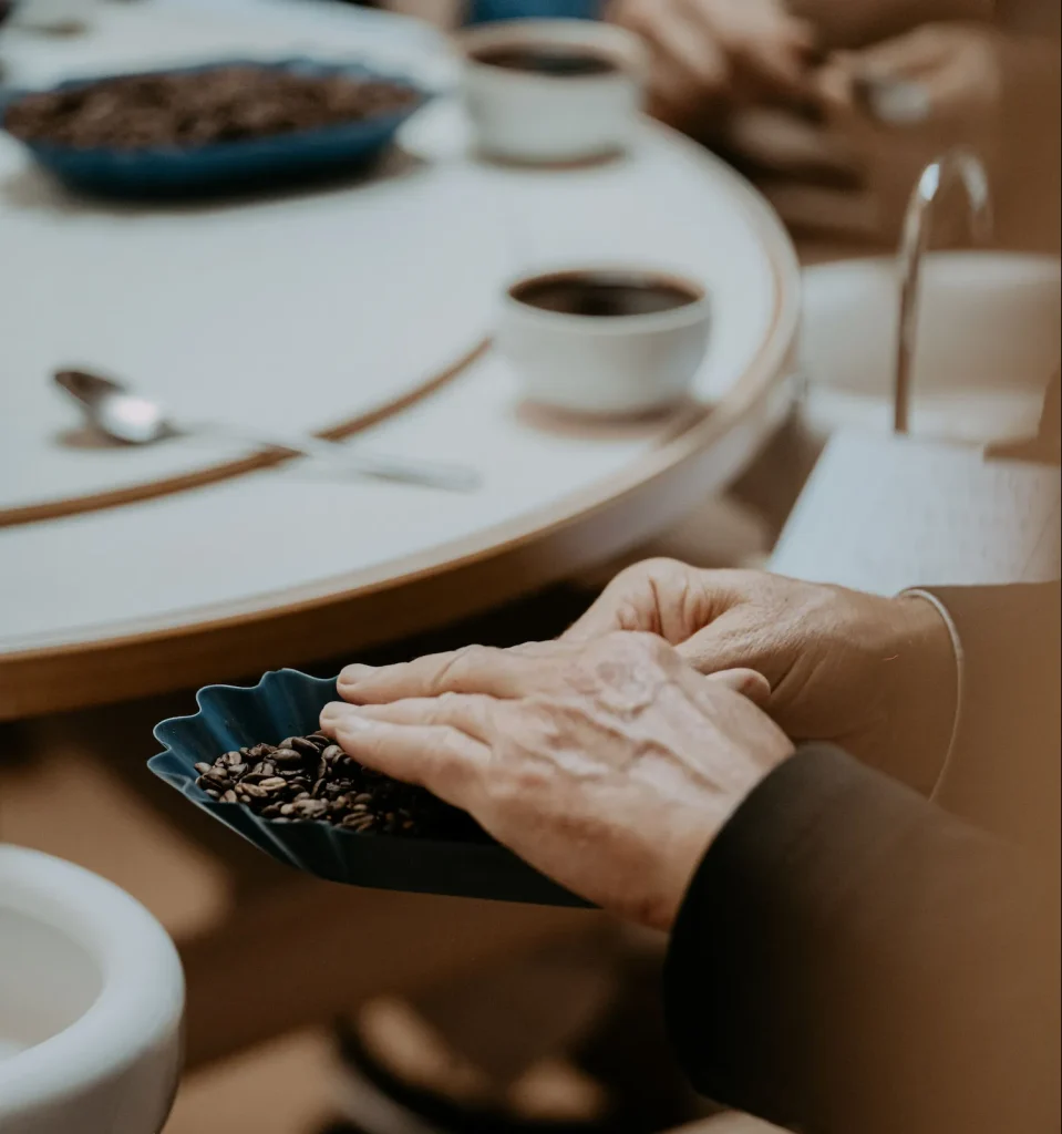 Mains tenant une coupelle de café en grains