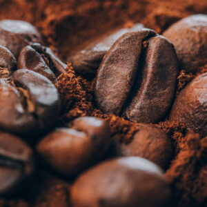 gros plan de grains de café torréfiés reposant sur du café moulu